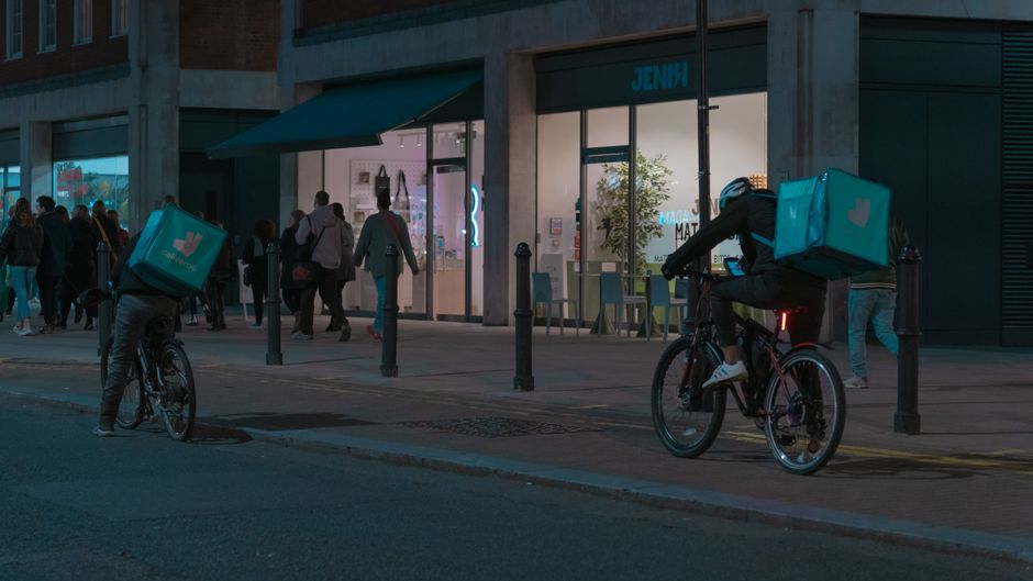 Couriers riding fixed-gear bikes through city traffic
